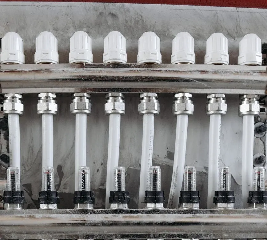 An underfloor heating manifold with flow meters and white pipe runs